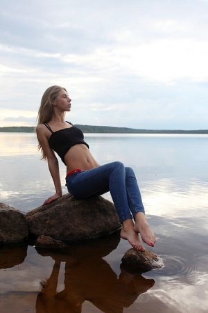 Girl next door Megan pulls out her tits while sitting on a rock in the lake porn photo #14
