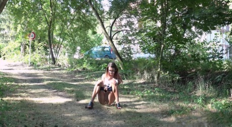 White girl Adele Unicorn takes a piss on a path inside of the woods